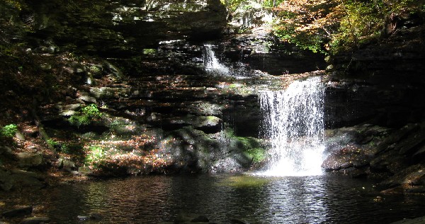 A sunlit waterfall in the shady glen